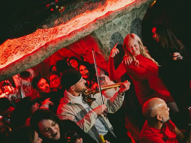 Invités qui dansent autour de Nathan Mignien au violon