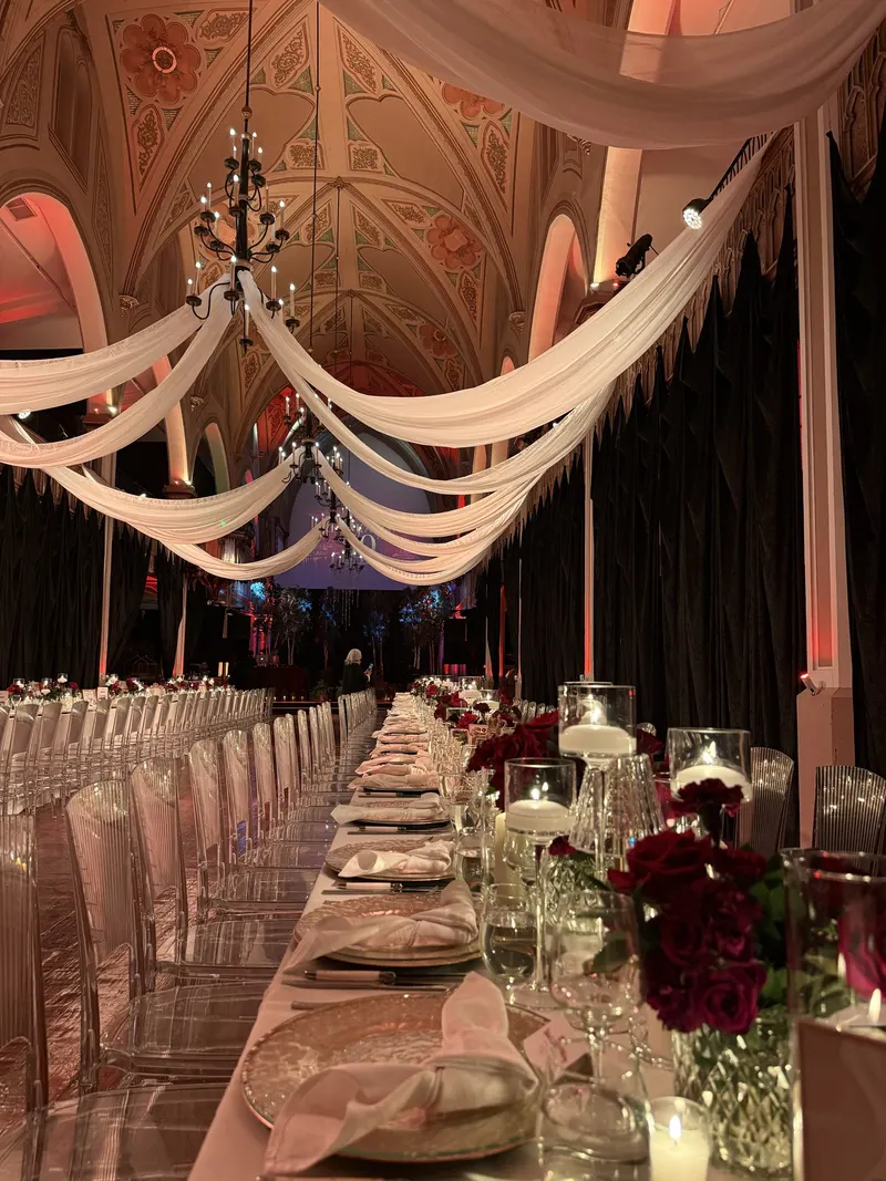 Salle de réception de mariage avec voilages, chandelles et roses